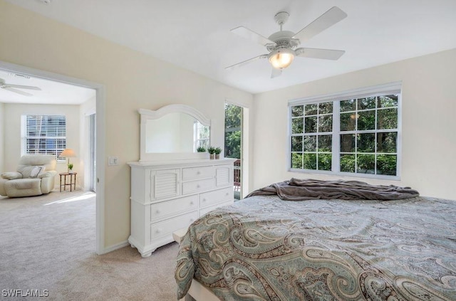 bedroom featuring light colored carpet, baseboards, and a ceiling fan