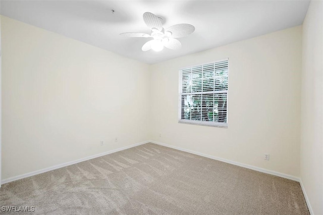 unfurnished room featuring light colored carpet, baseboards, and ceiling fan