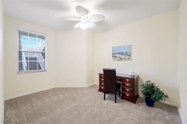 office space featuring ceiling fan, baseboards, and light carpet