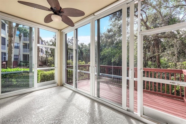 unfurnished sunroom with ceiling fan