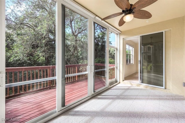 unfurnished sunroom featuring ceiling fan