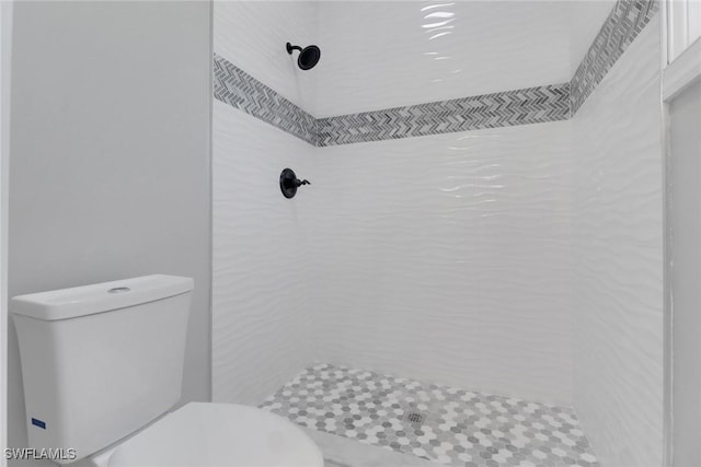 bathroom with tiled shower and toilet