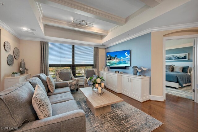 living room with dark wood-type flooring, a tray ceiling, and crown molding