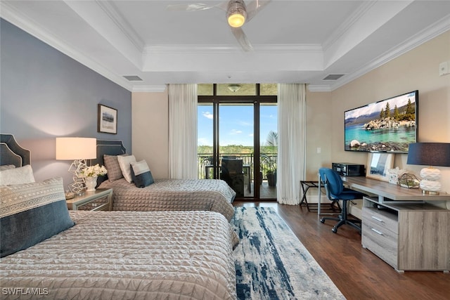 bedroom with a tray ceiling, access to outside, dark wood-style flooring, an office area, and ornamental molding