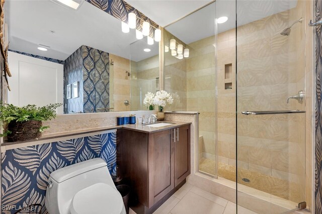 full bathroom with a tile shower, toilet, vanity, and tile patterned flooring