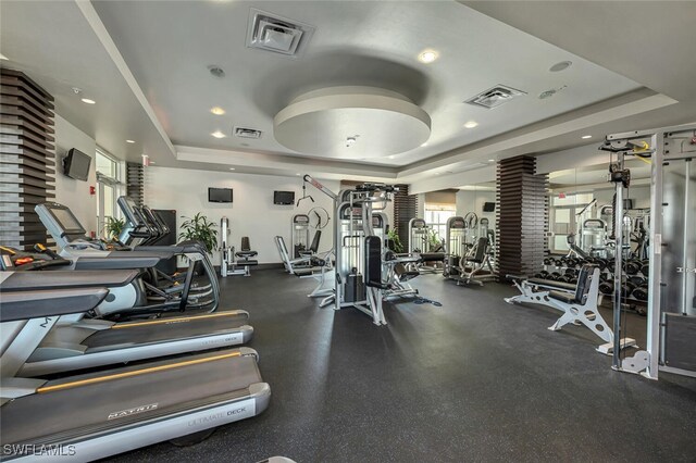 exercise room with a tray ceiling