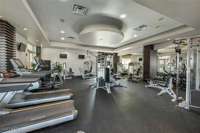 gym with recessed lighting, a raised ceiling, and visible vents