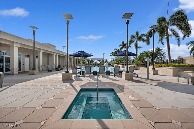 view of pool with a hot tub and a patio