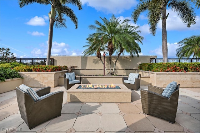 view of patio / terrace with an outdoor living space with a fire pit and fence