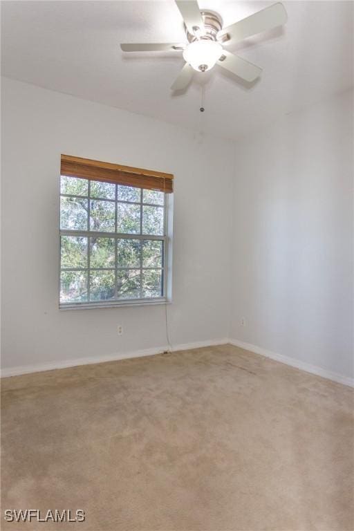 carpeted spare room with ceiling fan