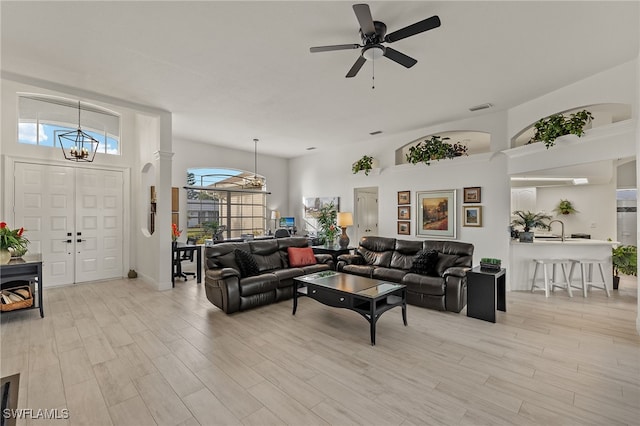 living room featuring ceiling fan with notable chandelier