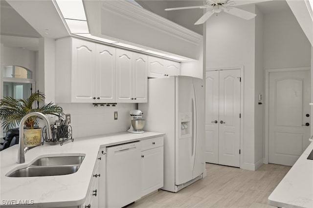 kitchen featuring ceiling fan, sink, tasteful backsplash, white appliances, and white cabinets