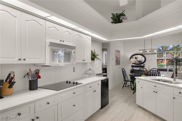 kitchen featuring black appliances, decorative backsplash, white cabinetry, and sink