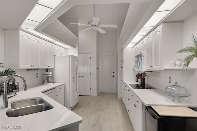 kitchen featuring white appliances, tasteful backsplash, white cabinetry, and sink