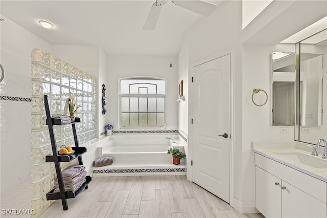 bathroom featuring vanity, ceiling fan, wood-type flooring, and a tub