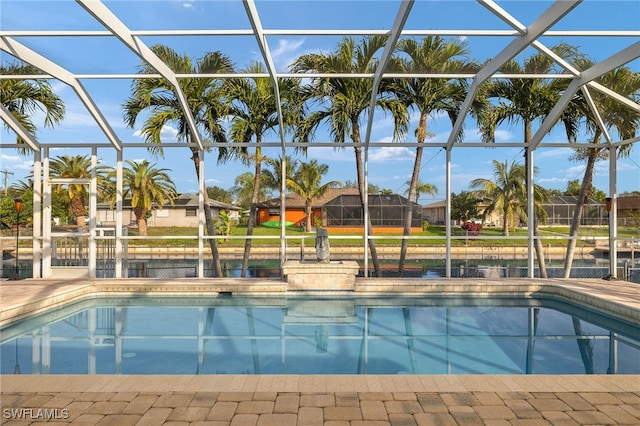 view of pool with glass enclosure and a patio area