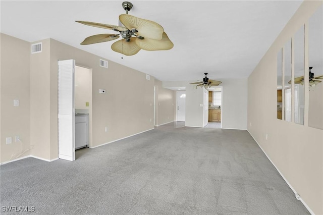 unfurnished living room featuring ceiling fan, carpet floors, visible vents, and baseboards