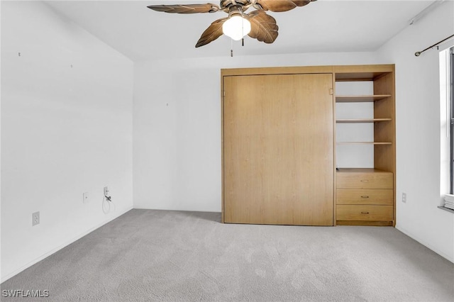 unfurnished bedroom with light carpet, ceiling fan, and a closet