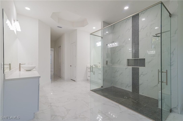 bathroom featuring a raised ceiling, vanity, and a shower with shower door