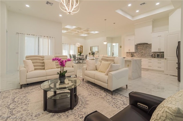 living room featuring a raised ceiling and an inviting chandelier