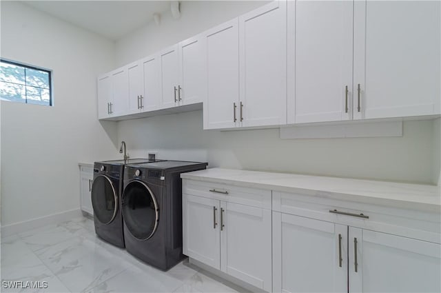 clothes washing area featuring cabinets and independent washer and dryer