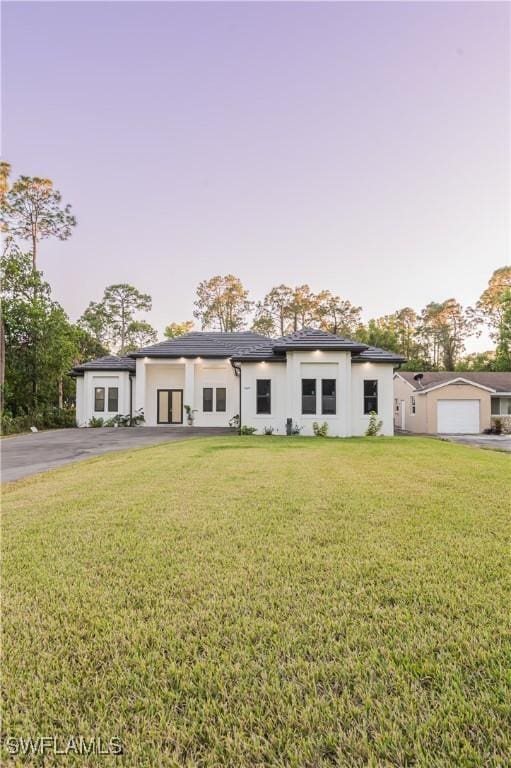 view of front of home featuring a front lawn and a garage