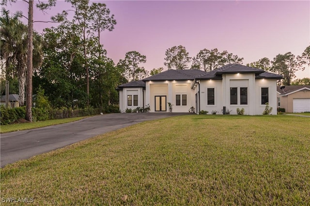 view of front of home with a yard and a garage