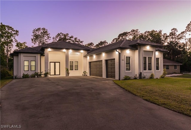 view of front of property featuring a garage and a lawn