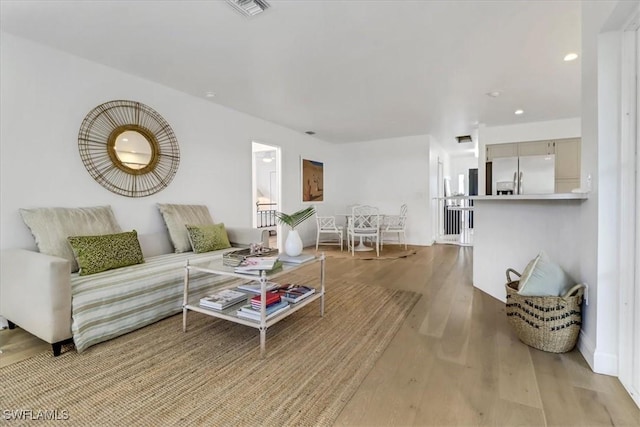 living room with visible vents, wood finished floors, and recessed lighting