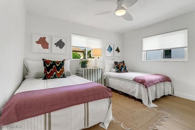 bedroom featuring a ceiling fan, baseboards, and wood finished floors