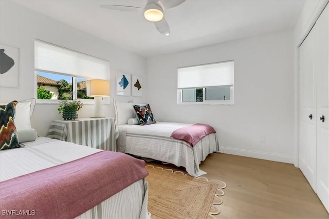 bedroom featuring baseboards, a closet, ceiling fan, and wood finished floors
