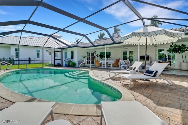 outdoor pool with glass enclosure, a patio area, and french doors