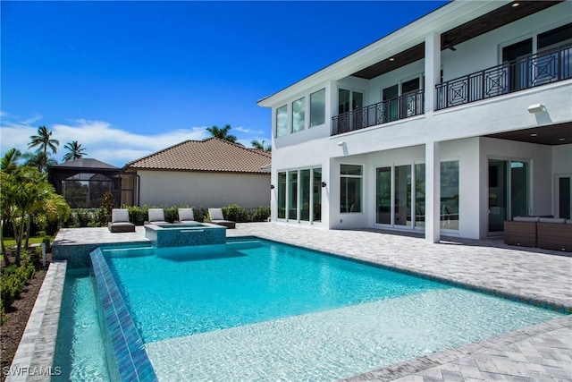 view of pool featuring a pool with connected hot tub, outdoor lounge area, and a patio area