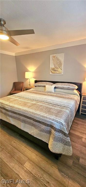 bedroom featuring ceiling fan, hardwood / wood-style floors, and crown molding