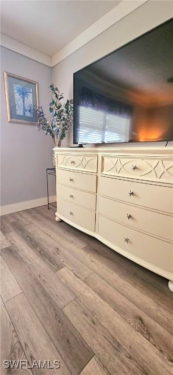 unfurnished bedroom featuring light wood-type flooring and crown molding