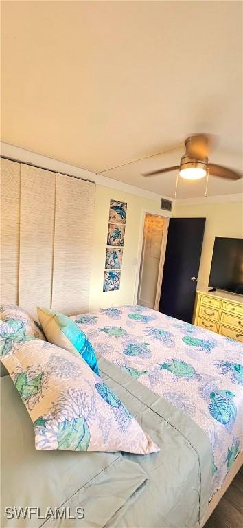 bedroom featuring ceiling fan, crown molding, and a closet