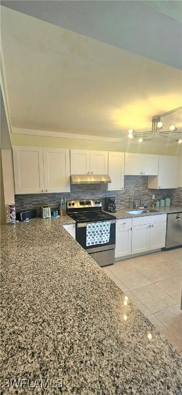 kitchen with white cabinets, sink, stainless steel appliances, and dark stone counters