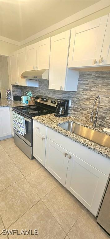 kitchen with decorative backsplash, electric range, sink, and white cabinets