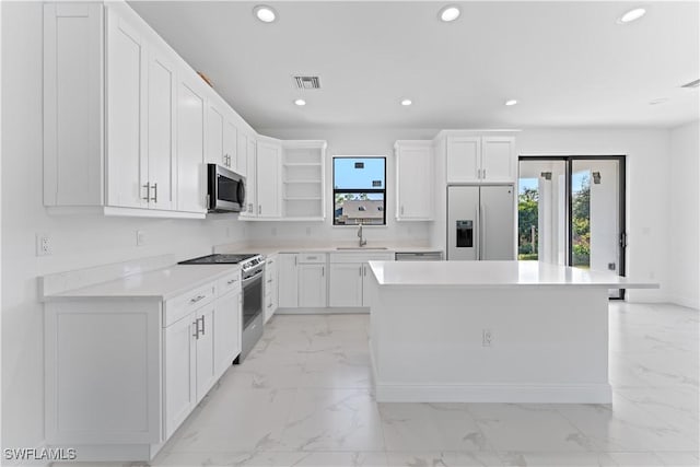 kitchen with sink, white cabinetry, a center island, and stainless steel appliances