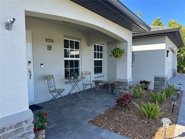 view of exterior entry featuring a porch and a garage