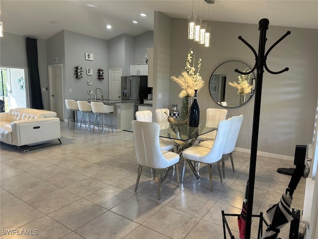 tiled dining space featuring a towering ceiling and a chandelier