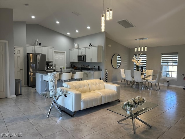 living room with light tile patterned floors and high vaulted ceiling