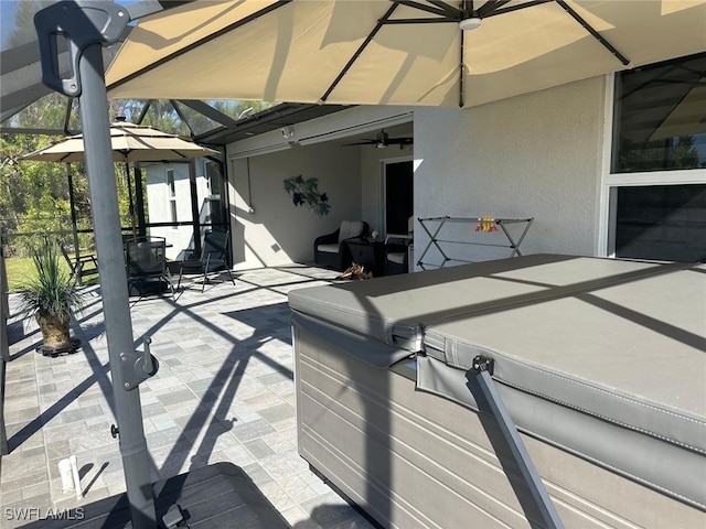 view of patio / terrace with ceiling fan and a lanai