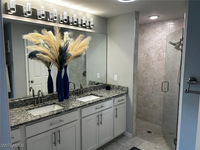 bathroom featuring tile patterned flooring, vanity, and a shower with door