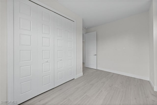 unfurnished bedroom featuring a closet and light hardwood / wood-style floors