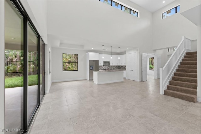 unfurnished living room with a towering ceiling