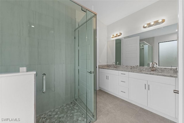 bathroom with tile patterned flooring, vanity, and a shower with door