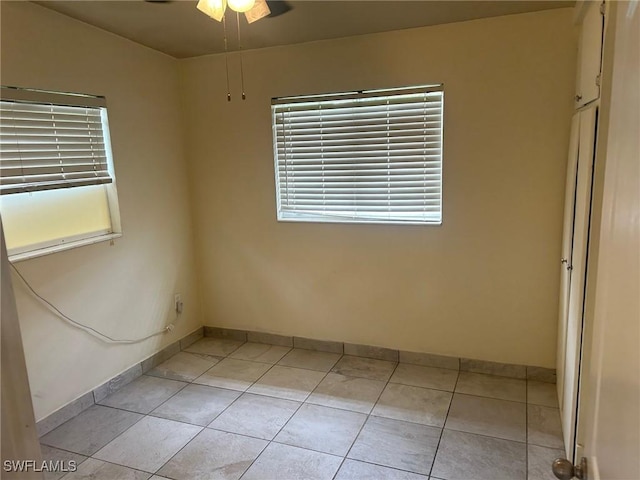 tiled spare room with ceiling fan