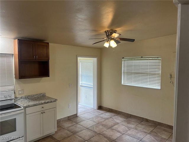 kitchen featuring electric range, ceiling fan, white cabinets, and light tile patterned floors