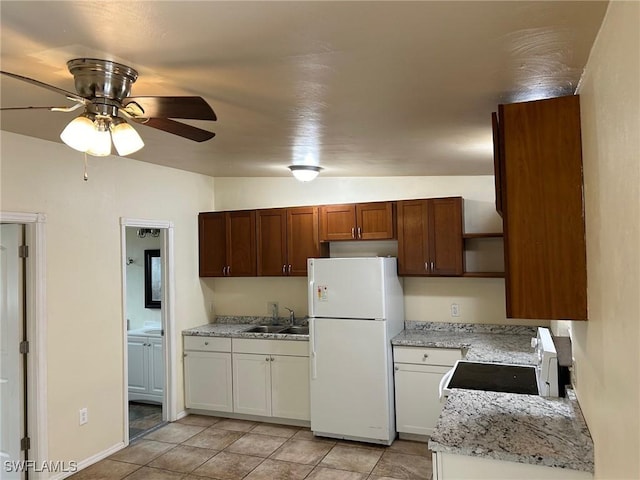 kitchen with ceiling fan, sink, white refrigerator, vaulted ceiling, and white cabinets